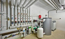 Heizungskeller einer Wohnanlage, Sole-Wasser-Wärmepumpe mit Pufferspeicher als hydraulische Weiche und Naturkühlung Heizungskeller einer Wohnanlage, Sole-Wasser-Wärmepumpe mit Pufferspeicher als hydraulische Weiche und Naturkühlung
